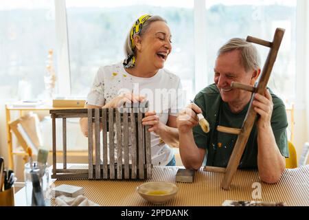 Glückliches Seniorenpaar, das sich in der Werkstatt amüsiert Stockfoto