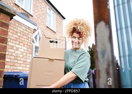 Glückliche junge Frau mit Pappkartons Stockfoto