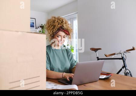 Glückliche junge Geschäftsfrau auf Laptop am Schreibtisch arbeiten Stockfoto