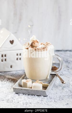 Tasse heiße weiße Schokolade mit Schlagsahne und Zimt Stockfoto
