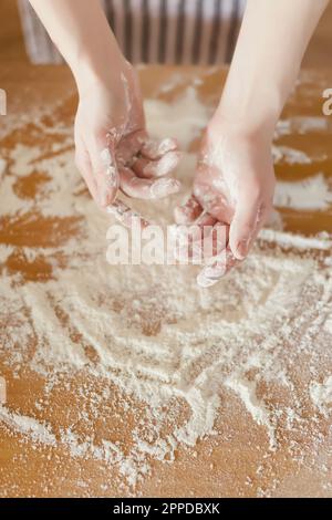 Hände einer Frau, mit Mehl bedeckt Stockfoto