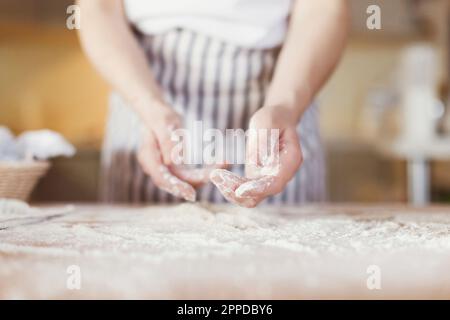 Hände einer jungen Frau, mit Mehl bedeckt Stockfoto