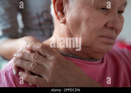 Tochter tröstet und unterstützt Seniorvater zu Hause Stockfoto