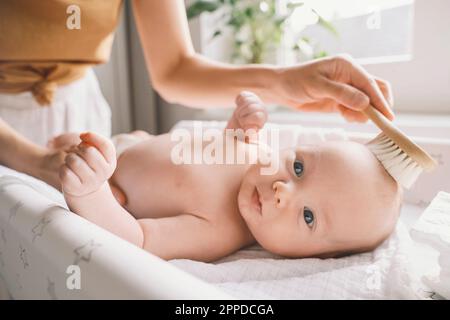 Mutter, die das Haar eines Jungen zu Hause putzt Stockfoto