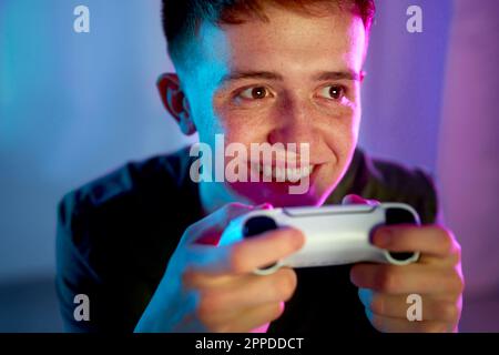 Glücklicher junger Mann, der Videospiele spielt Stockfoto