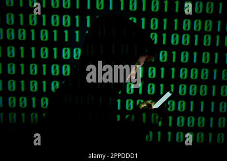 Mann, der ein Smartphone mit binären Codes benutzt Stockfoto