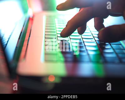 Im Heimbüro können Sie im Dunkeln mit den Händen auf der Laptop-Tastatur tippen Stockfoto