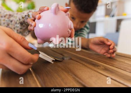 Mutter eröffnet Sparschwein, um zu Hause Münzen zu zählen Stockfoto