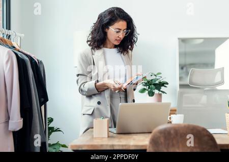 Modedesignerin, die Farbmuster im Studio überprüft Stockfoto