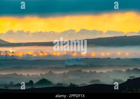 Spanien, Kanarische Inseln, Masdache, Lichter des Dorfes im Parque Natural de Los Volcanes bei nebiger Dämmerung Stockfoto