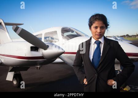 Die Pilotin steht vor ihrem Flugzeug Stockfoto