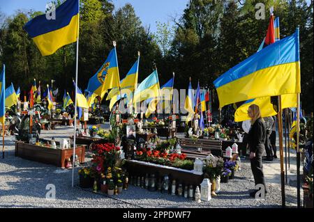 Lemberg, Ukraine. 23. April 2023. Eine Frau steht an einem Grab eines geliebten Menschen auf dem Marsfeld auf dem Friedhof Lychakiv. Die Menschen besuchen die gefallenen Helden der Ukraine, die das Territorium der Ukraine auf dem Friedhof Lychakiv verteidigten, wo sie begraben sind. Russland marschierte am 24. Februar 2022 in die Ukraine ein und löste damit den größten militärischen Angriff in Europa seit dem Zweiten Weltkrieg aus Kredit: SOPA Images Limited/Alamy Live News Stockfoto