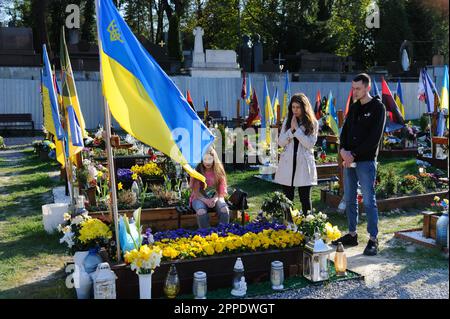 Lemberg, Ukraine. 23. April 2023. Die Menschen beten am Grab eines geliebten Menschen auf dem Marsfeld auf dem Friedhof Lychakiv. Die Menschen besuchen die gefallenen Helden der Ukraine, die das Territorium der Ukraine auf dem Friedhof Lychakiv verteidigten, wo sie begraben sind. Russland marschierte am 24. Februar 2022 in die Ukraine ein und löste damit den größten militärischen Angriff in Europa seit dem Zweiten Weltkrieg aus Kredit: SOPA Images Limited/Alamy Live News Stockfoto