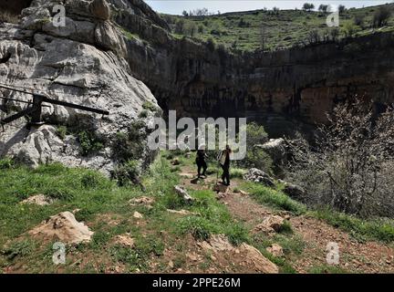 Beirut, Libanon. 23. April 2023. Zwei Frauen wandern im Baatara Schlagloch im Dorf Balaa, Batroun District, Libanon, 23. April 2023. Das Baatara-Schlagloch, auch bekannt als Balaa-Schlucht, befindet sich im Dorf Balaa in Tannourine im Viertel Batroun im Libanon. Kredit: Liu Zongya/Xinhua/Alamy Live News Stockfoto