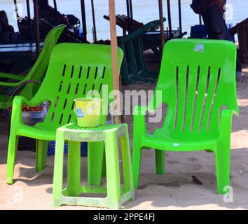 Zwei grüne Plastikstühle am Strand, Meer im Hintergrund, warten auf Kunden, die sitzen und trinken in Dongtan Beach, Jomtien, Pattaya, Thailand, Asien, Stockfoto