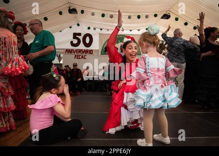 Barcelona, Spanien. 23. April 2023. Eine junge Dame unterrichtet ein Mädchen in einem Zelt während des 50. Jahrestages der Aprilmesse in Barcelona über Svillanas. Am Sonntag, dem 23. April, besuchten Tausende von Menschen die Feria de Abril in Barcelona, um die berühmte Feria de Sevilla zu eröffnen. Frauen und Männer tanzten in traditionellen Kostümen. (Foto: Ximena Borrazas/SOPA Images/Sipa USA) Guthaben: SIPA USA/Alamy Live News Stockfoto