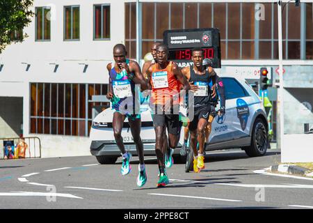 Madrid, Spanien. 23. April 2023. Der ugandische Sportler Geoffrey Kusuro (L) und der kenianische Sportler Bernard Kipkemboi (C) während des Zürcher Rock 'n' Roll Running Series Madrid Marathon. An der Sportveranstaltung (Zürich Rock 'n' Roll Running Series Madrid Marathon) nahmen mehr als 35.000 Läufer Teil, darunter fast 10.000 ausländische Athleten aus 110 Ländern. Die Gewinnerinnen waren Kusuro (2:10:29), Sila Kiptoo (2:10:31) und Bernard Kimkemboi (2:10:32). Kredit: SOPA Images Limited/Alamy Live News Stockfoto