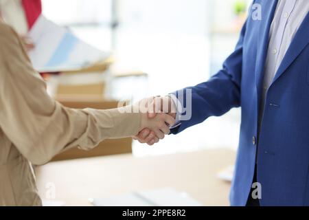 Geschäftspartner geben sich die Hand und schätzen den Deal im Büro Stockfoto