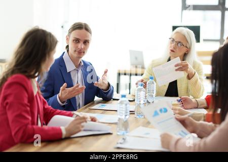 Ein junger Manager informiert seine Kollegen bei der Besprechung Stockfoto