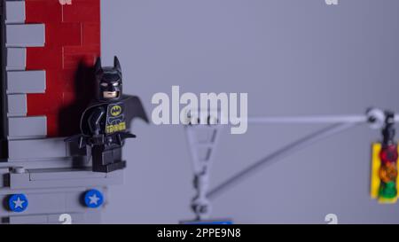 Ein Mann kleidet sich wie batman und versteckt sich an der Wand Stockfoto