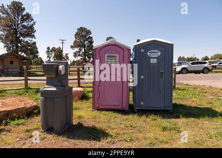 Zwei tragbare Toiletten im Freien, eine rosafarbene für Frauen und eine Handwaschstation im Freien bei einem Festival im Freien. Stockfoto