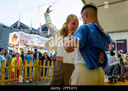 Barcelona, Spanien. 23. April 2023. Ein junges Paar wird beim Flamenco-Tanz während der Feierlichkeiten für die Messe „Feria de Abril“ im Forum Park gesehen. Die Messe, auch bekannt als Sevilla Fair, stammt ursprünglich aus der andalusischen Stadt Sevilla, wo Menschen sich sieben Tage lang treffen, um traditionelle Flamenco-Musik zu trinken und zu tanzen. Kredit: SOPA Images Limited/Alamy Live News Stockfoto