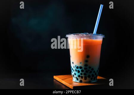 Beliebter Seifenblasentee in einem großen Glas auf dunklem Hintergrund, Bar-Theke. Trendige asiatische Sommergetränke Stockfoto