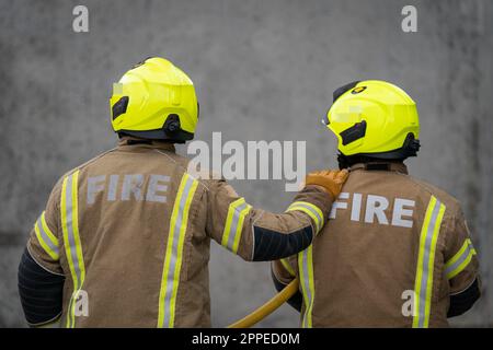 HINWEIS FÜR REDAKTEURE: NAMEN VERSCHWOMMEN AUF VERLANGEN DER LONDONER FEUERWEHR Datei Foto vom 21.07/22 von neuen Rekruten der Londoner Feuerwehr gehen während einer Übung in einer Feuerwache im Osten Londons durch. Im Rahmen eines neuen britischen Forschungsprojekts, das von der Fire Brigades Union (FBU) in Auftrag gegeben wird, soll eine lebensrettende Krebsüberwachung von Feuerwehrleuten gestartet werden. Die Tests werden diese Woche im Großraum Manchester von der University of Central Lancashire (UCLan) unter der Leitung von Professor Anna Stec durchgeführt. Ausgabedatum: Montag, 24. April 2023. Stockfoto