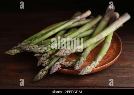 Frischer roher Spargel auf Holztisch, Nahaufnahme Stockfoto