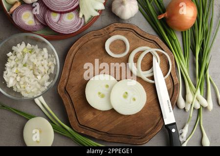 Flache Laienzusammensetzung mit Zwiebel auf grauem Tisch Stockfoto