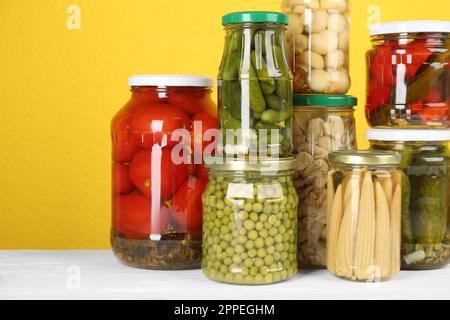 Eingelegte Gemüsegläser auf einem weißen Holztisch Stockfoto