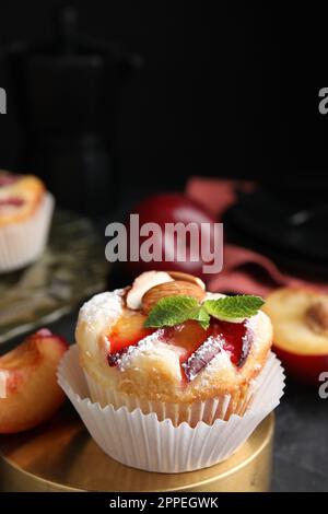 Leckere Cupcakes mit Pflaumen auf schwarzem Tisch, Nahaufnahme Stockfoto