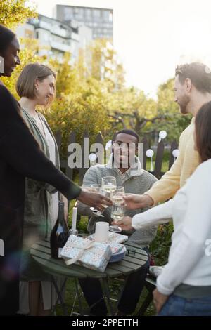 Fröhliche Freunde feiern im Garten Stockfoto