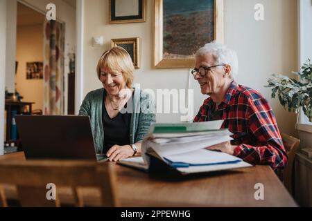 Älteres Paar mit Laptop zu Hause Stockfoto
