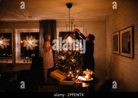Vater und Tochter schmücken Weihnachtsbaum Stockfoto