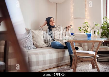 Frau sitzt auf dem Sofa im Wohnzimmer Stockfoto