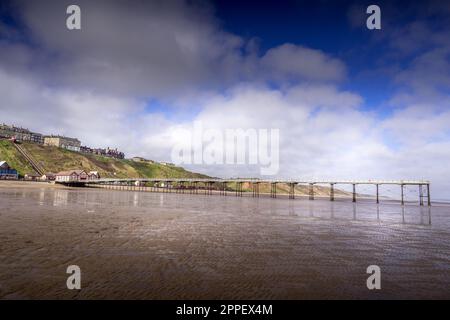 Der viktorianische Pier bei Saltburn, der sich bei Ebbe über den Strand erstreckt. Stockfoto