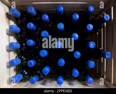 Flaschen Wein auf hölzernen Regalen in einem Weingut. Stockfoto