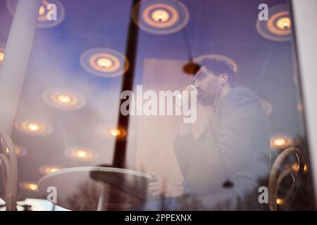 Eleganter Mann, der Kaffee im Café trinkt Stockfoto