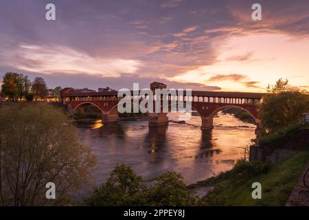 Schöne Aussicht auf Ponte Coperto (überdachte Brücke) über den Tessin in Pavia zur Blue Hour, Lombardei, italien. Stockfoto