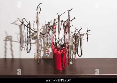 Der originale Halter für Schmuck in Form eines Baumes, handgefertigt. Produkte mit Dekorationen auf der Kommode. Inneneinrichtung, originelle Idee. clos Stockfoto