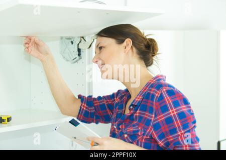 Eine Frau, die ihren eingebauten Schrank inspiziert Stockfoto