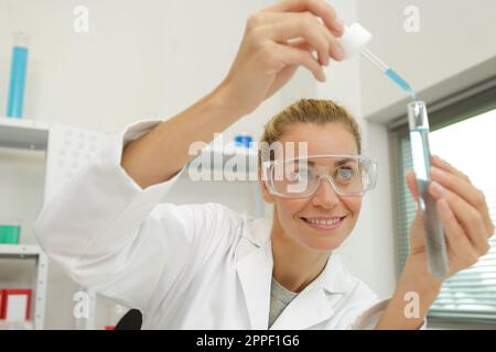 Frau mit Pipetten und Reagenzgläsern Stockfoto