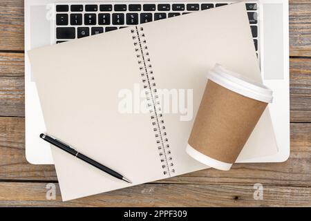 Laptop, Notebook und Einweg-Pappbecher, Draufsicht. Stockfoto