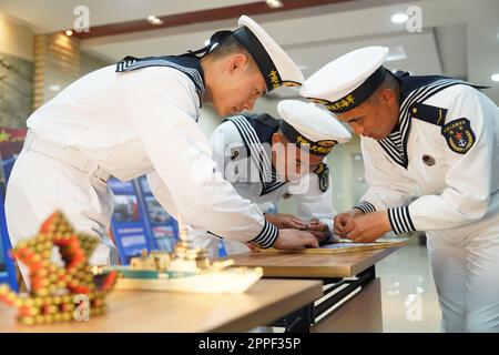 (230424) -- QINGDAO, 24. April 2023 (Xinhua) -- Soldaten der Marine des Eastern Theater Command der chinesischen Volksbefreiungsarmee (PLA) bereiten ein Artefakt zum Gedenken an den 74. Gründungstag der PLA Navy am 23. April 2023 vor. Die PLA Navy hat im ganzen Land eine Reihe von Open-Day-Aktivitäten organisiert, um ihren 74. Gründungstag, der am Sonntag stattfand, zu feiern. Seit Freitag sind insgesamt 62 Kasernen der PLA Navy in 22 Städten, darunter Qingdao, Dalian, Shanghai und Guangzhou, für die Öffentlichkeit zugänglich. ZU „China Focus: PLA Navy feiert ihren Gründungstag mit Witze Stockfoto