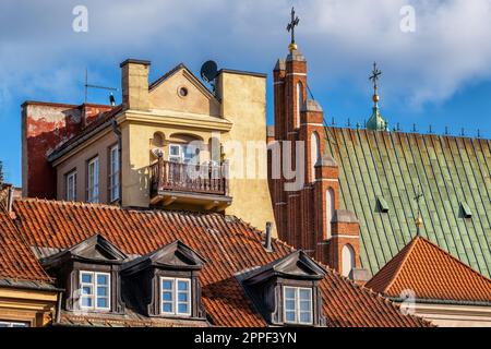 Historische Architektur der Altstadt in Warschau, Polen. Im Mietshaus befindet sich ein Dach mit Dachfenstern und einem Dach der Erzkathedrale von St. John. Stockfoto