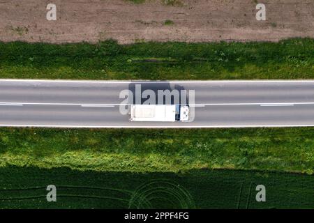 Transport und Logistik, Luftaufnahme eines Lastwagens, der am sonnigen Sommertag auf der Autobahn durch die Landschaft fährt Stockfoto