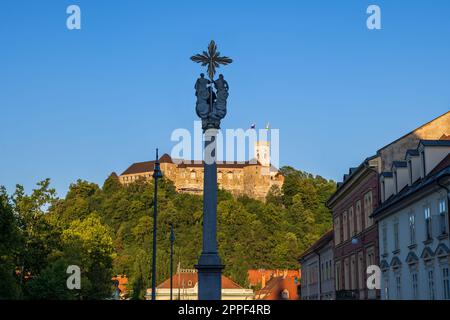 Dreifaltigkeitssäule bei Sonnenuntergang vor der Burg Ljubljana in der Stadt Ljubljana in Slowenien. Stockfoto