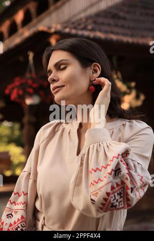 Eine schöne Frau, die im Dorf ein gesticktes Kleid trägt. Ukrainische Nationalkleidung Stockfoto