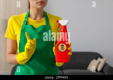 Frau zeigt eine Flasche giftiger Haushaltschemikalien mit Warnschild, Nahaufnahme Stockfoto